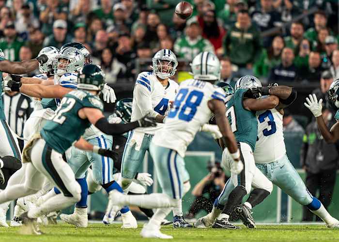 Dak Prescott yells as he looks to CeeDee Lamb and Eagles players swarm him